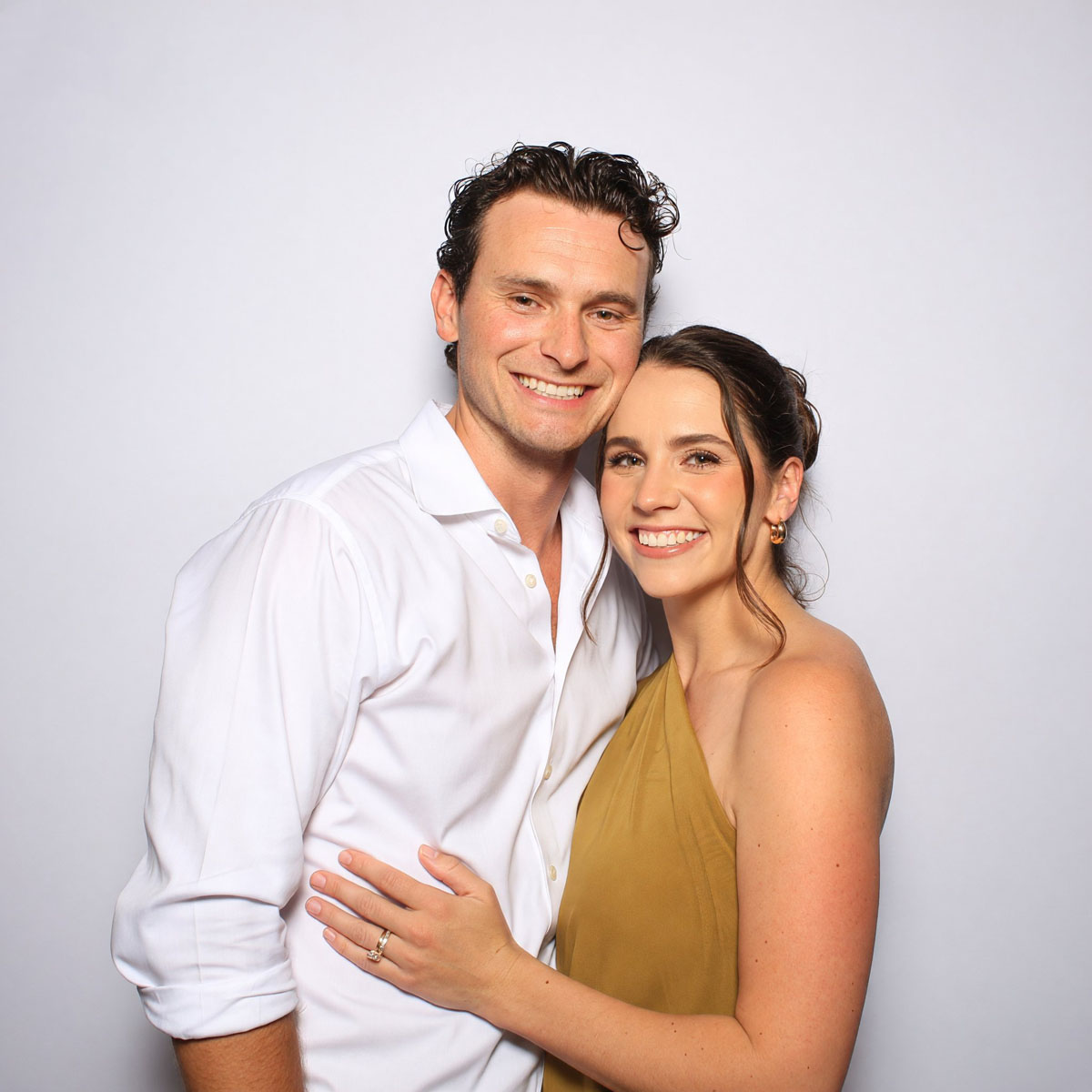 Pareja retratada en la cabina de fotos, sobre fondo blanco